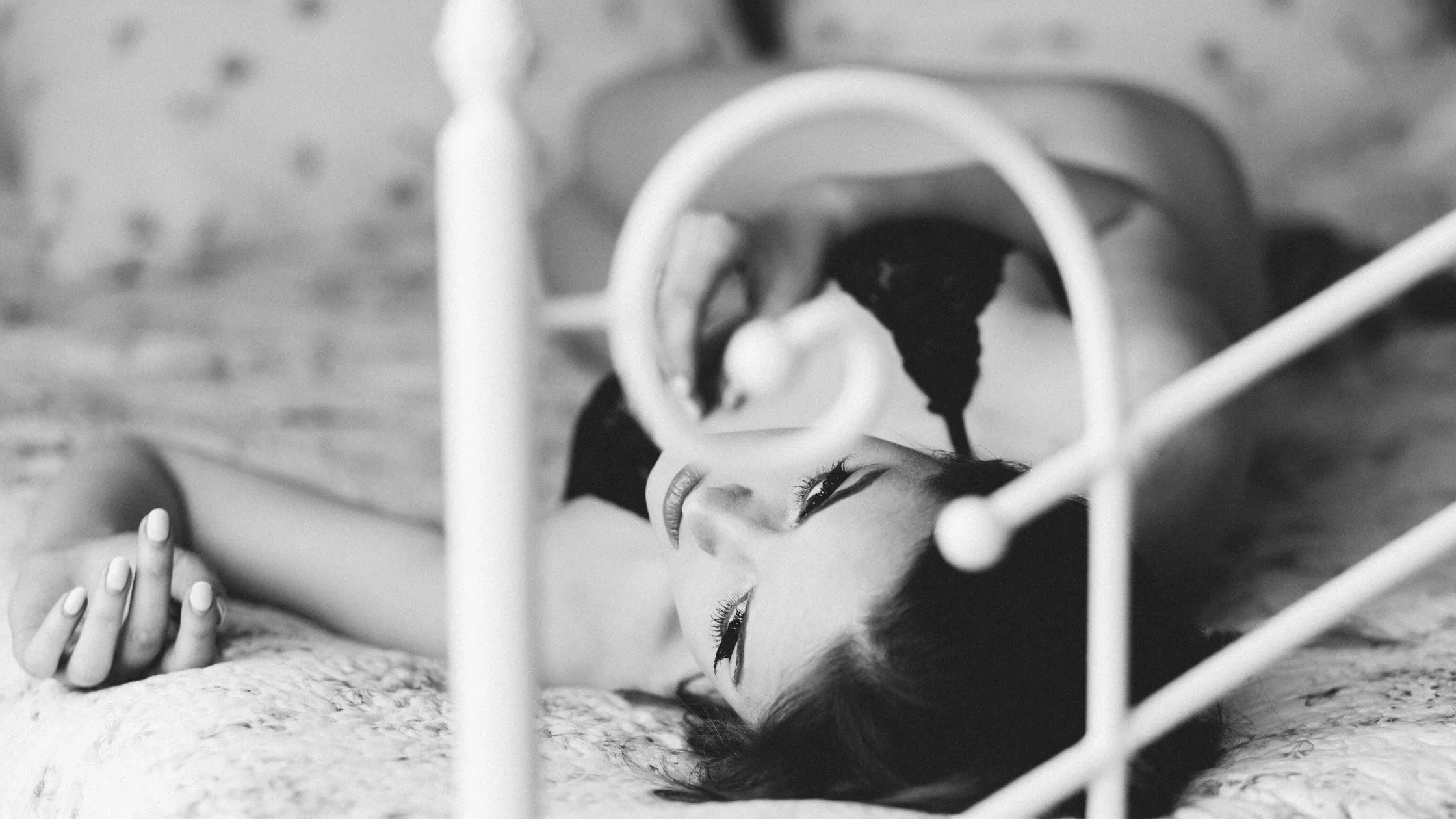 Vintage photo of woman lying on a bed in black lingerie